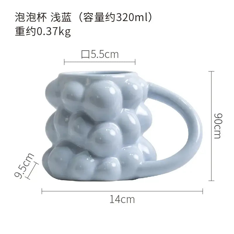 A light blue ceramic mug with bubbly three dimensional texture and smooth handle decorbites grape ceramic design