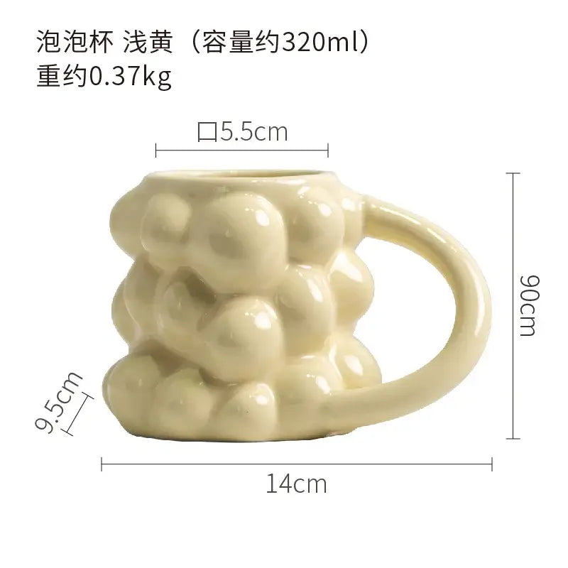 A pale yellow ceramic mug with a textured bubbly surface and smooth handle from decorbites grape ceramic mug collection