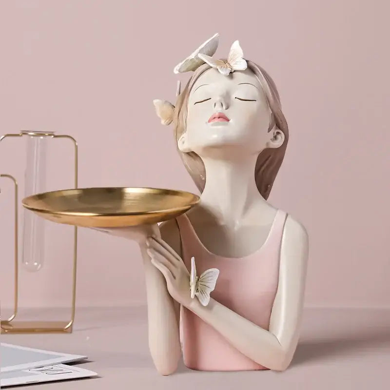 A delicate pastel butterfly fairy resin figurine with closed eyes wearing pink holding a gold tray for living room decorbites decor