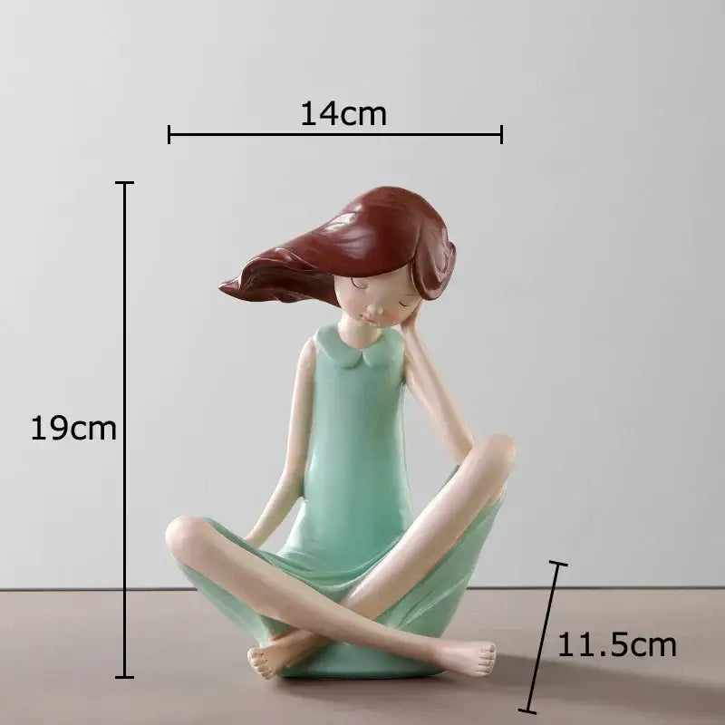 A pastel cartoon girl resin sculpture of a serene seated girl with reddish brown hair in a light green dress decorbites cartoon girl