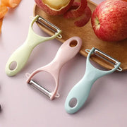 Three pastel ceramic kitchen peelers with stainless steel blades on wooden board beside apples by decorbites ceramic