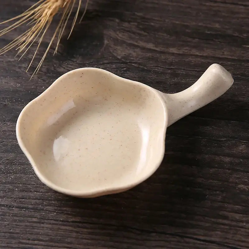 Cream-colored speckled ceramic milk cup creamer with leaf-shaped design and integrated handle for decorbites ceramic milk set