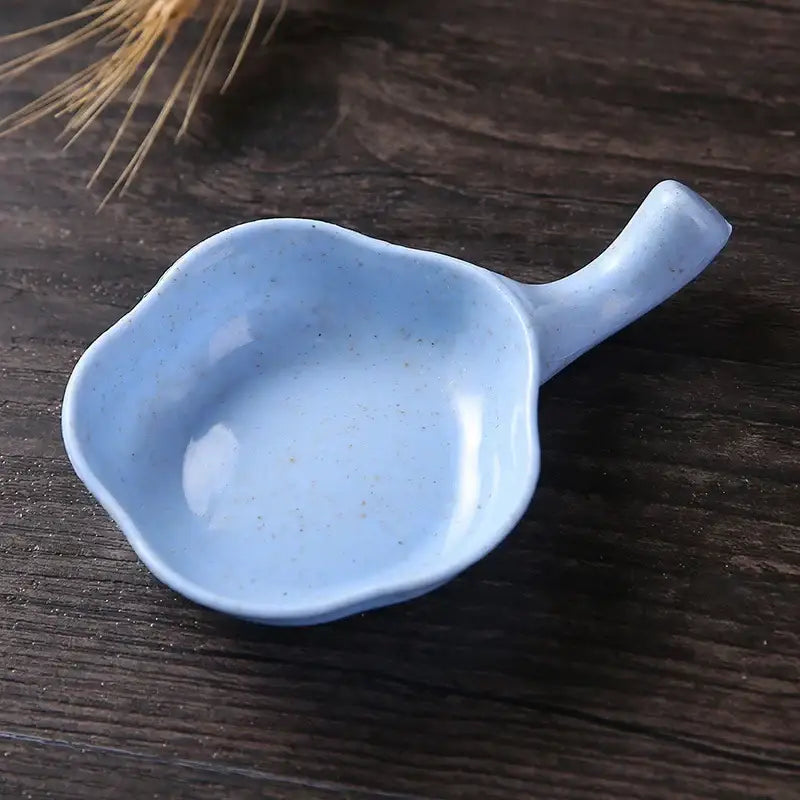A light blue speckled pastel ceramic milk cup creamer shaped like a leaf with a handle by decorbites ceramic milk