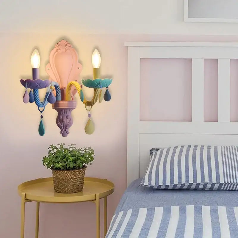 Pastel-colored ornate wall sconce with three candle-style lights and decorbites colorful crystal teardrop pendants for kids bedroom