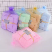 Pastel coral velvet bath towel set wrapped in sheer mesh bags with gold ribbons for soft absorbent velvet bath linens