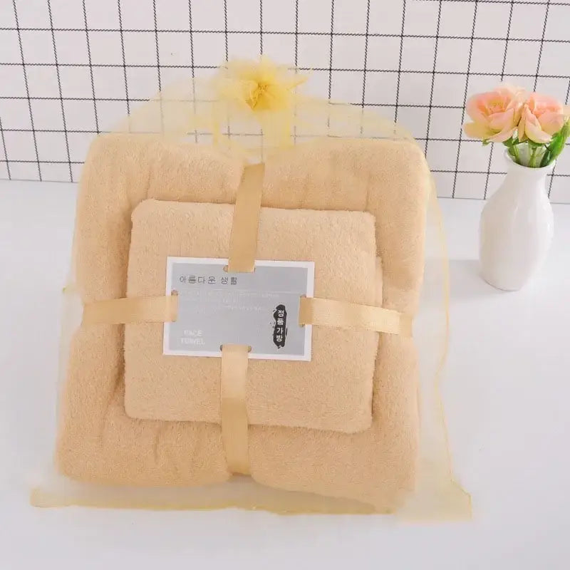 Beige plush pastel coral velvet bath towel set wrapped in yellow mesh with ribbon and decorative flower for soft absorbent linens