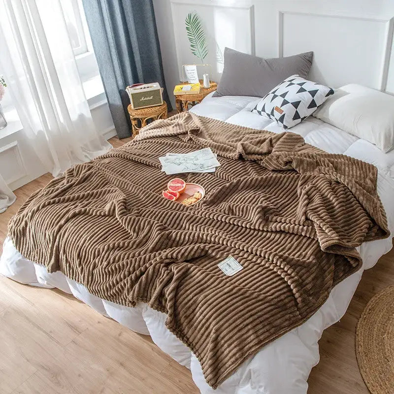 Brown corduroy cozy hug blanket with ribbed texture draped over bed soft sweatshirt throw by decorbites