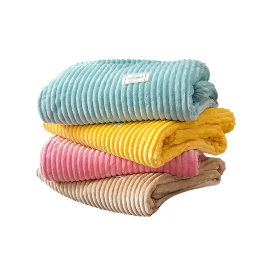 Stack of four pastel corduroy cozy hug blankets in soft blue yellow pink and beige soft sweatshirt throw decorbites cozy hug