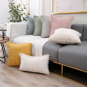 Set of pastel corduroy pompom cushion covers with colorful pom-pom trim for living room decor on gray sofa