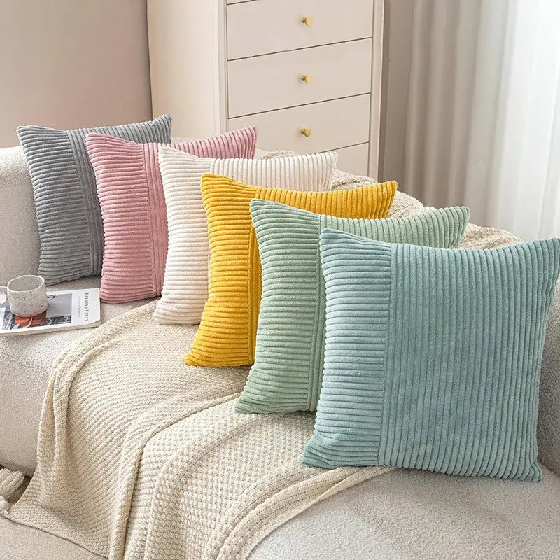 A collection of pastel corduroy striped body pillows in gray pink white yellow and mint green for bedroom lumbar support
