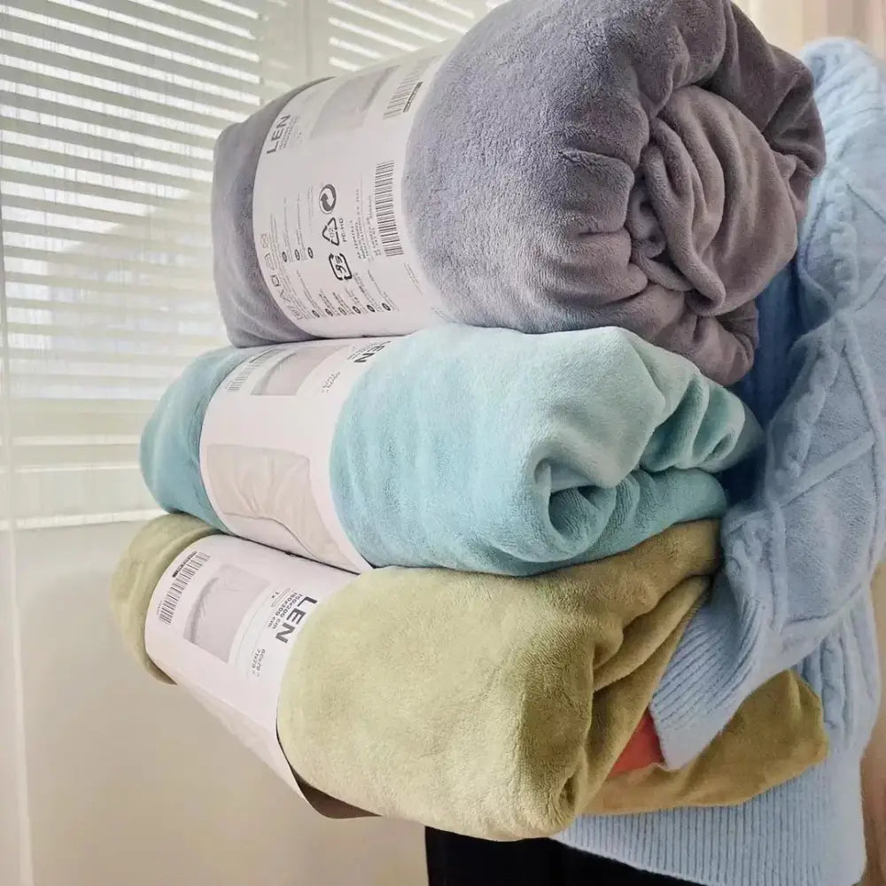 Stack of three rolled gray light blue and olive green decorbites cozy flannel queen bed sheet plush blankets with labels