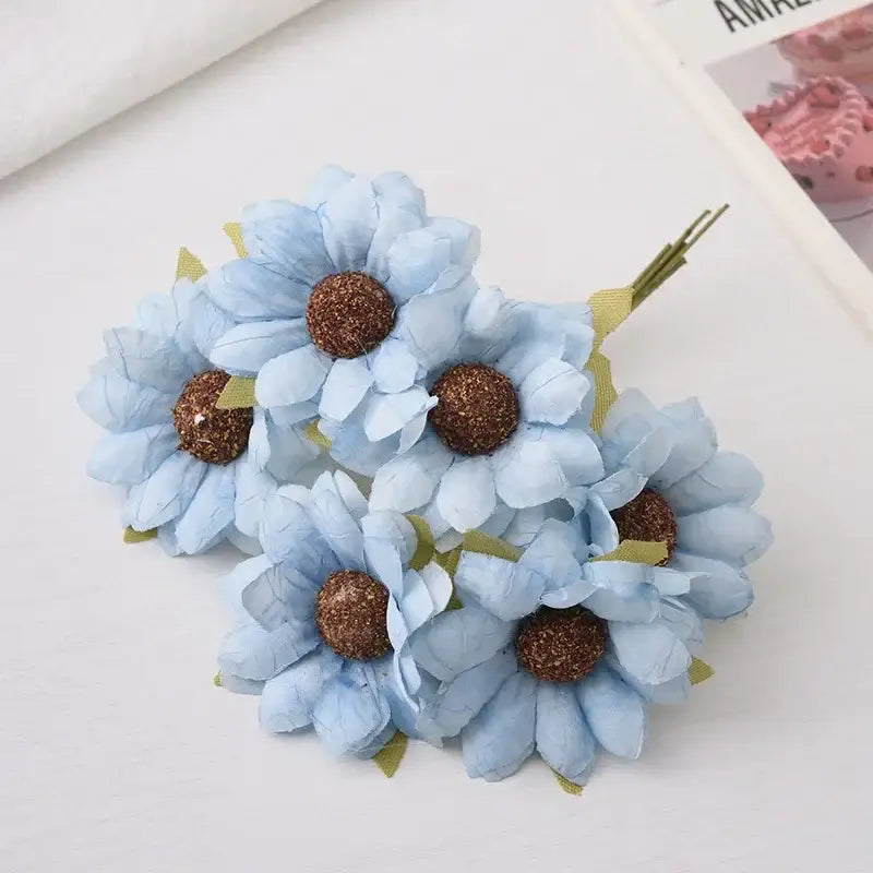 A pastel decorbites daisy sunflower bouquet with light blue artificial daisies and glittery brown centers for wedding decor