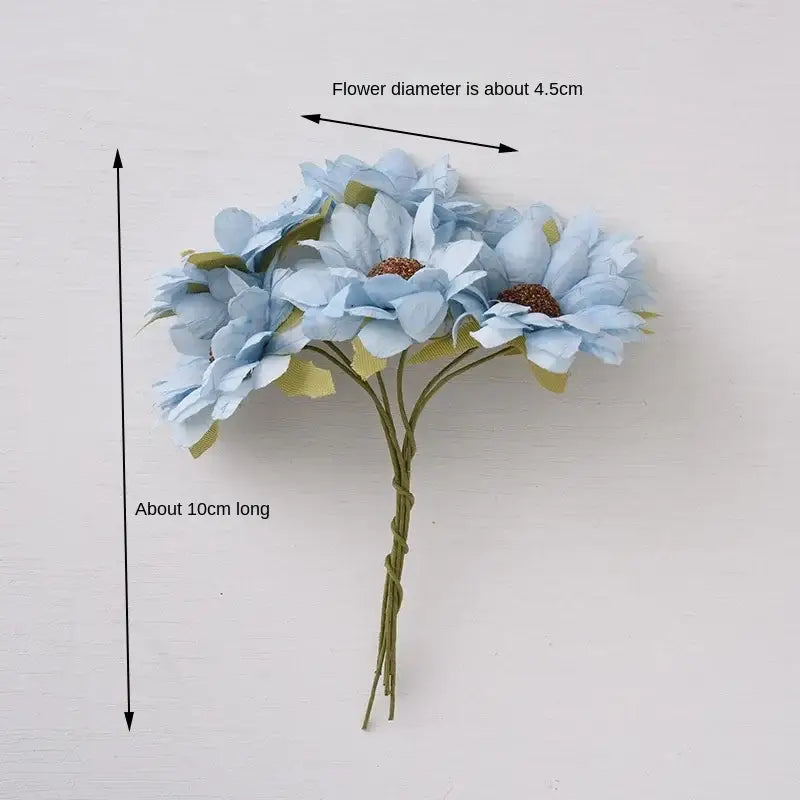A delicate pastel decorbites daisy sunflower bouquet of light blue artificial flowers with brown centers for wedding decor