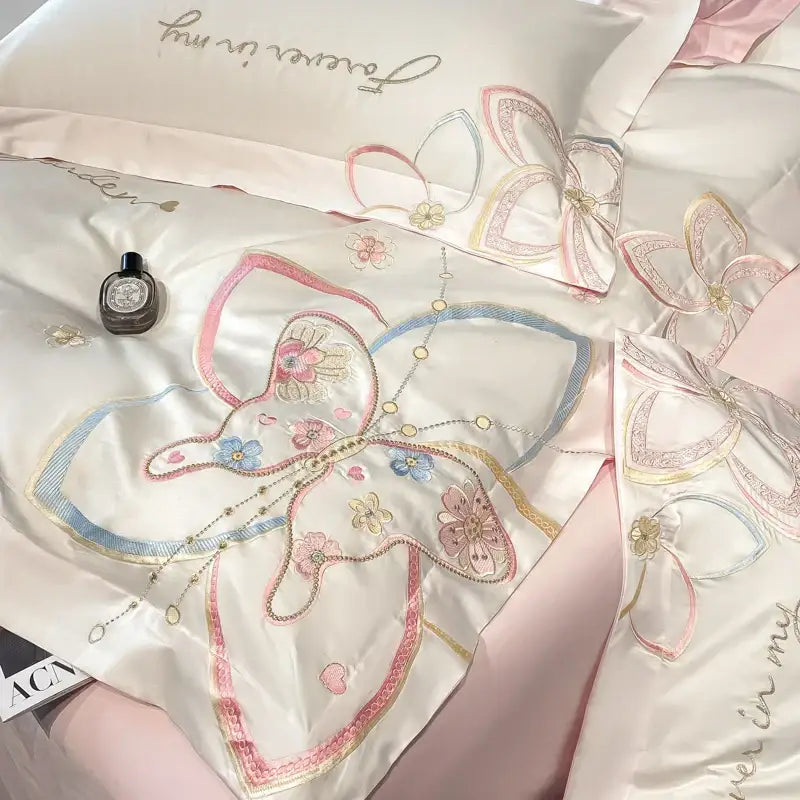 Delicate ivory satin bedding set with pastel decorbites embroidered butterfly flowers in pink blue and gold thread detailing