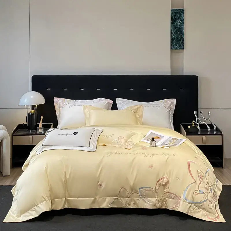 Cream-colored satin bedding set with delicate embroidered butterfly flowers and gold thread accents by decorbites