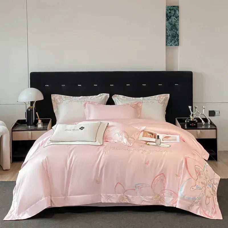 Pink satin bedding set with decorbites embroidered butterfly flowers and matching pillows for elegant bedroom decor