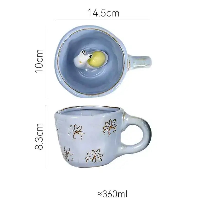A light blue ceramic cartoon animal coffee mug with gold daisy details and whimsical 3d cartoon duckling interior