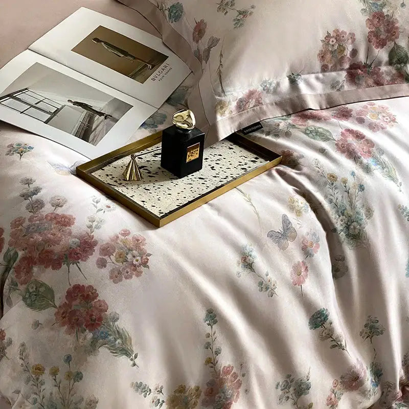 A black bvlgari perfume bottle with gold cap on a tray beside pastel floral flowers prints bedding set decorbites satin duvet cover