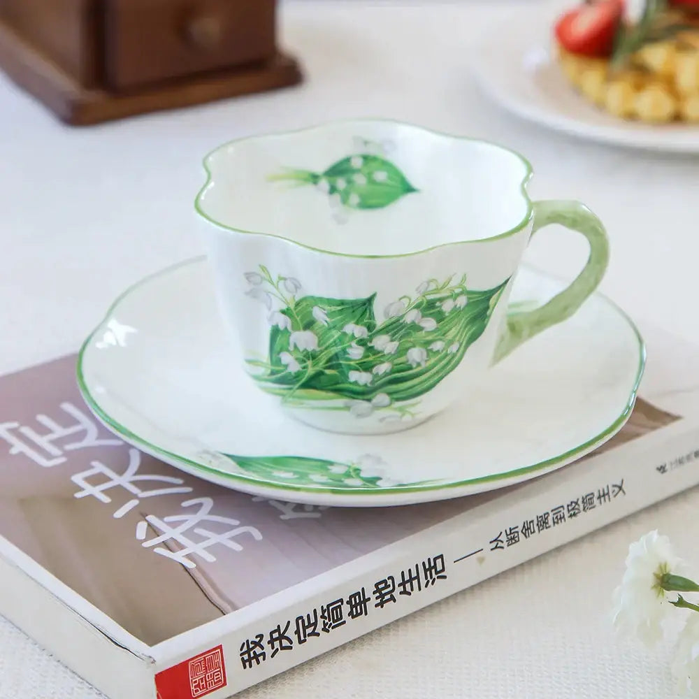 Delicate white porcelain coffee cup and saucer set with green lily of the valley decorbites bone hand-painted design