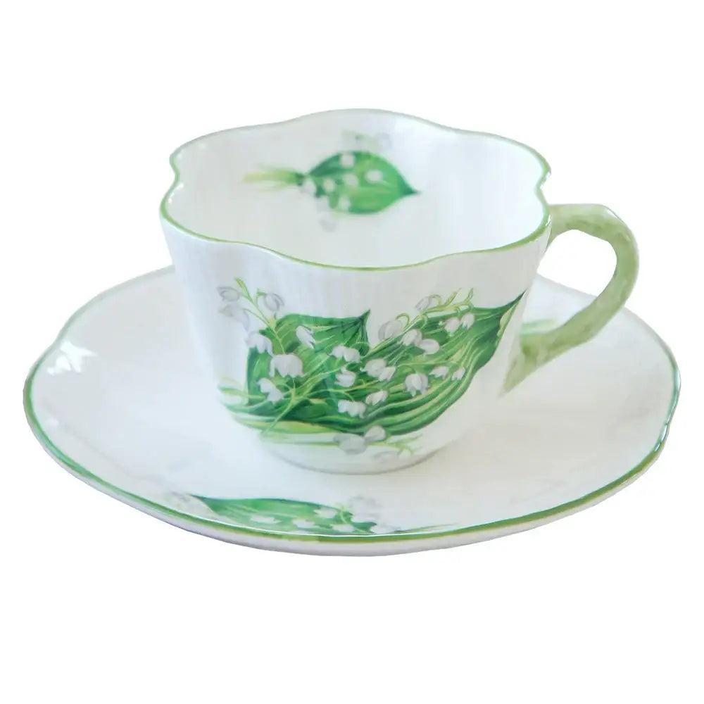 Delicate white porcelain coffee cup and saucer set with hand-painted green lily-of-the-valley design by decorbites bone