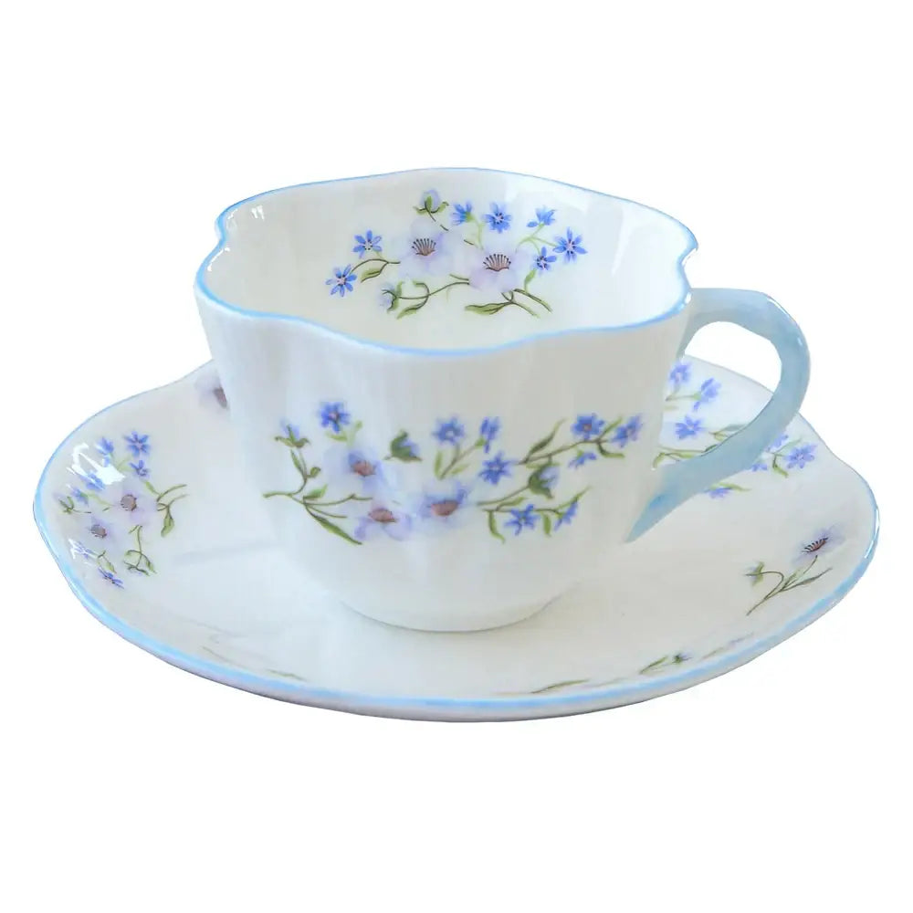 Pastel floral porcelain coffee cup and saucer set in white with delicate blue decorbites bone patterns and trim