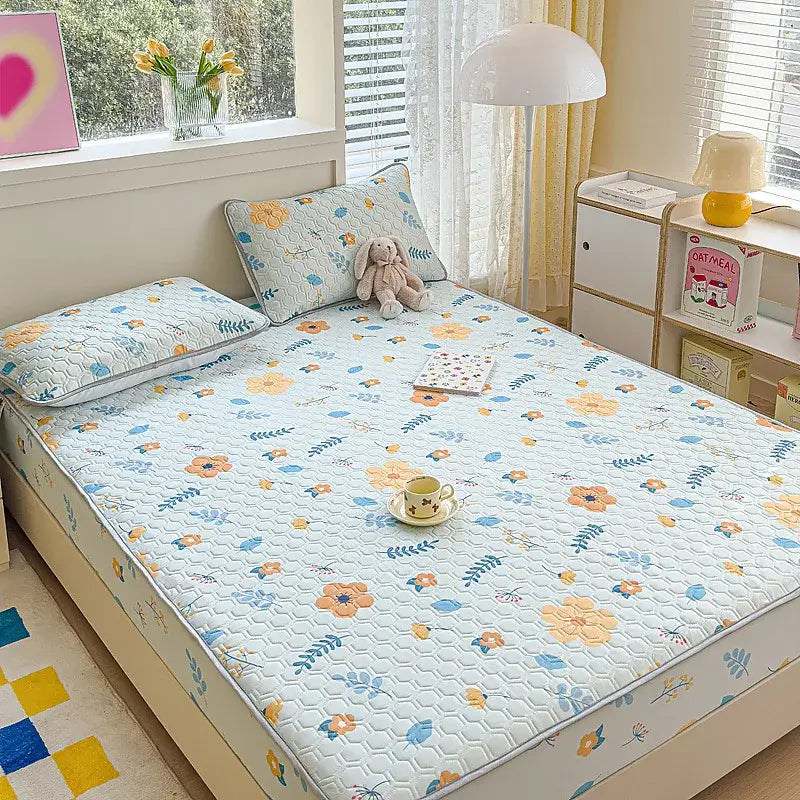 Light blue quilted latex fitted sheet set with cheerful orange and blue floral pattern and subtle hexagonal stitching
