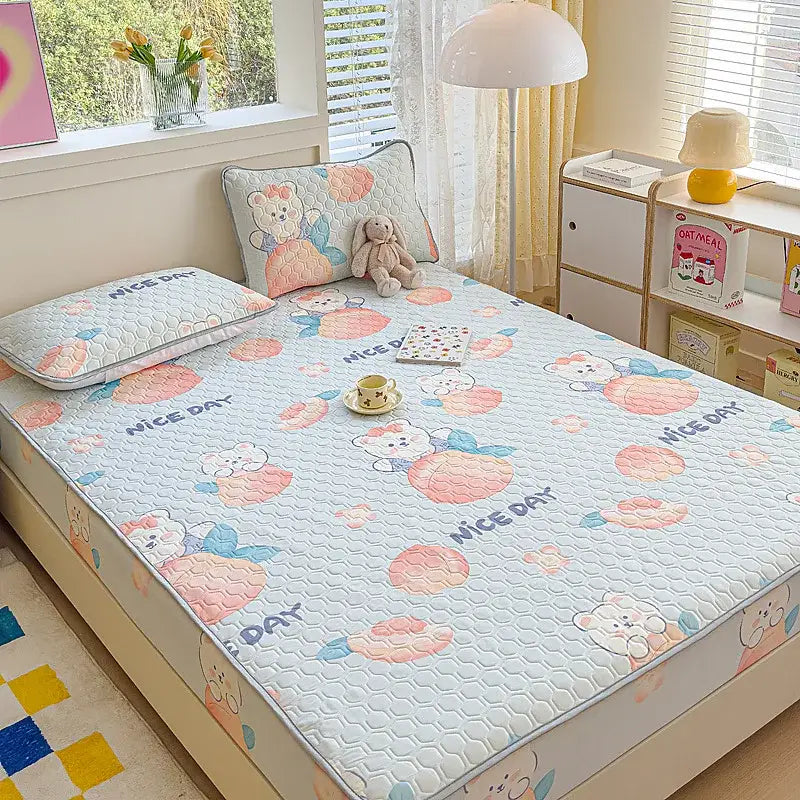 Light blue quilted latex bed pad with playful bear pattern and nice day text in pastel floral fitted sheet set