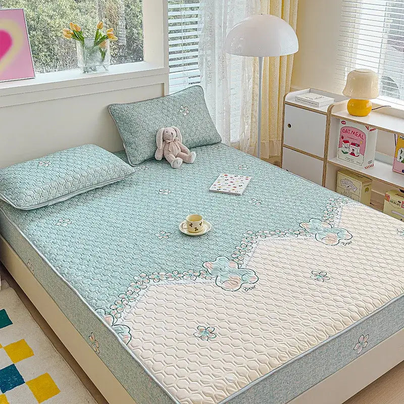 Light blue quilted latex fitted sheet set with cream floral and bunny design along the edge for bedroom use