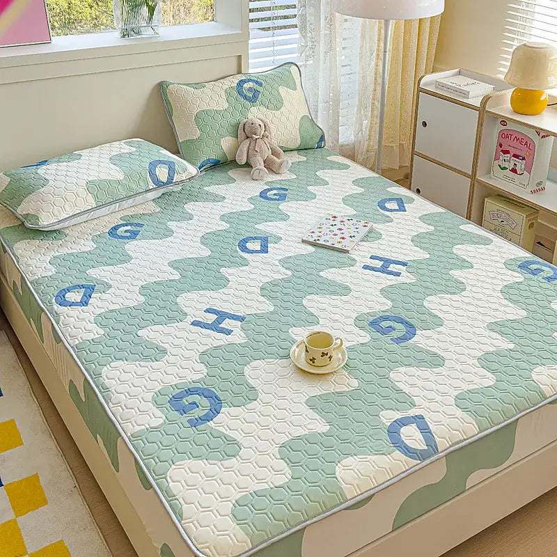 Pastel floral quilted latex fitted sheet set with soft mint green and white quilted bed pad featuring blue embroidered letters