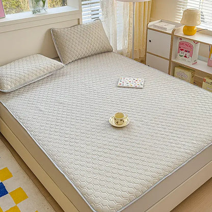 White hexagonal-patterned quilted bed pad with subtle gray border for pastel floral quilted latex fitted sheet set