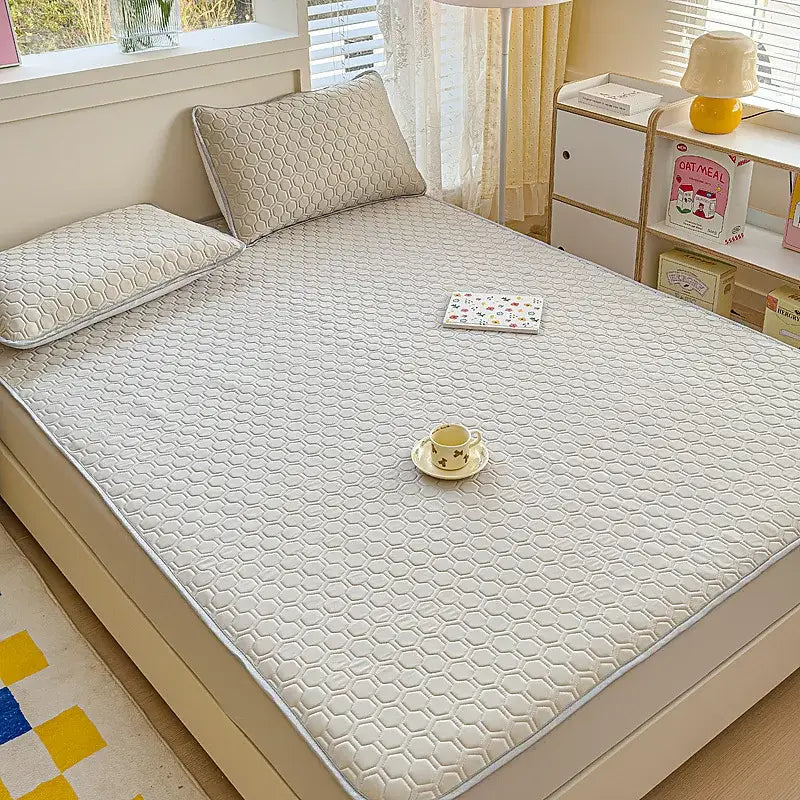 White hexagonal-patterned quilted bed pad with subtle gray border for pastel floral quilted latex fitted sheet set