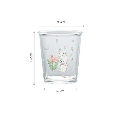 Clear glass rabbit glass tea tumbler with white bunny holding pink tulip and pastel floral patterns for coffee use