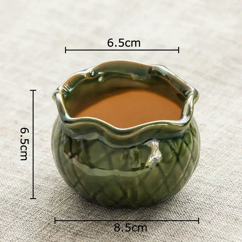 A glossy olive green lotus flower ceramic succulent pot with wavy rim and embossed leaf pattern for decorbites lotus flower decor