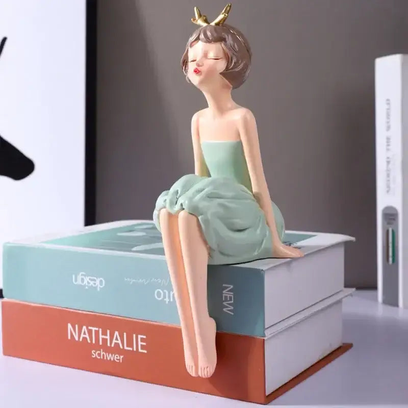 A delicate resin bowknot fairy girl figurine with golden antlers wearing a pastel green strapless dress for decor