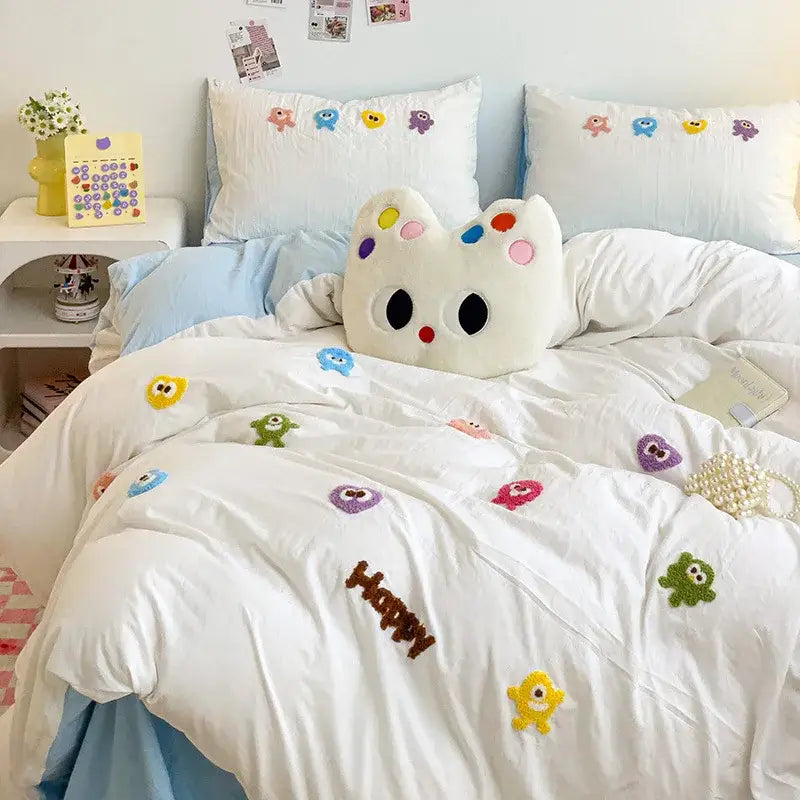 White plush cat-shaped pillow with colorful embroidery complements pastel green decorbites cartoon embroidery bedding set