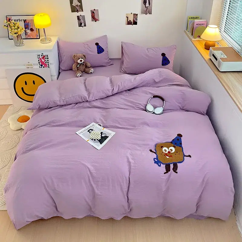 Purple quilted bedding set with decorbites cartoon embroidery featuring a cookie character in blue party hat