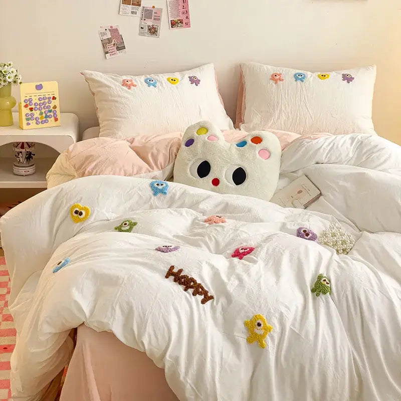 White plush cat-shaped pillow with colorful embroidered eyes and nose in pastel green cartoon embroidery bedding set decorbites