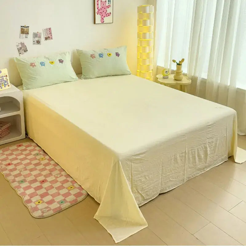 Pastel green cartoon embroidery bedding set featuring soft pale yellow quilted comforter with ruffled hemline and matching pillows