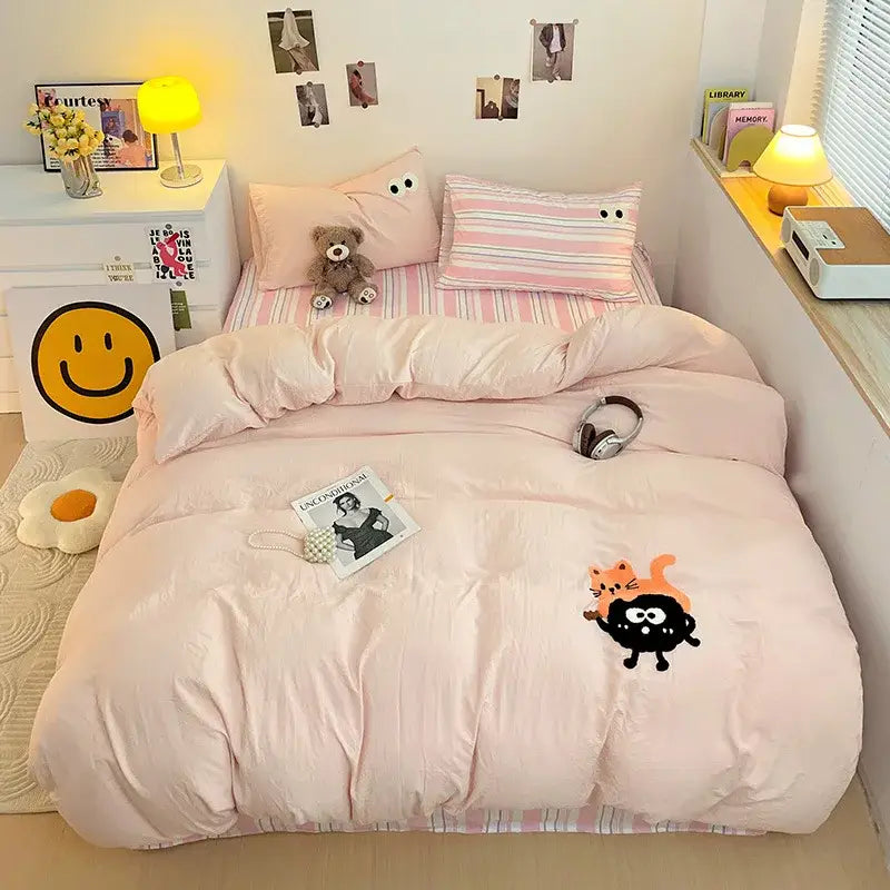 Pink quilted duvet bedding set with decorbites cartoon embroidery featuring a playful black and orange cat design