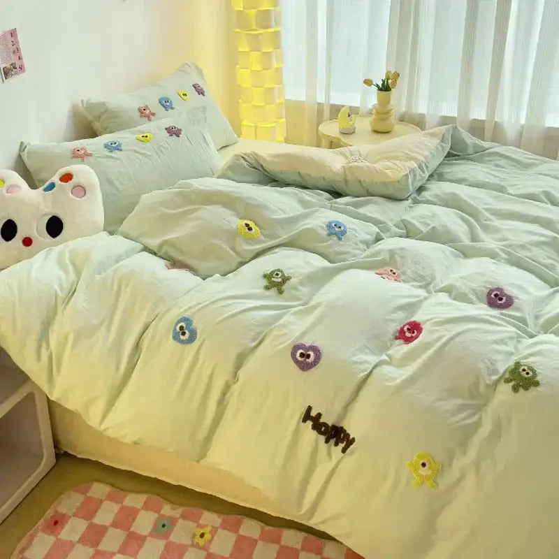 Pastel green quilted bedding set with colorful decorbites cartoon towel embroidery featuring happy faces