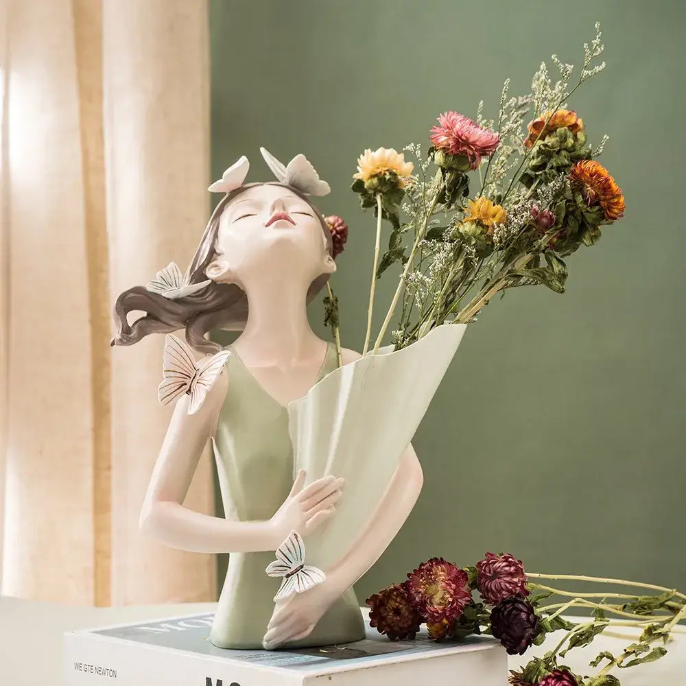 A delicate porcelain butterfly girl vase statue in pastel green with white butterfly accents for living room decor
