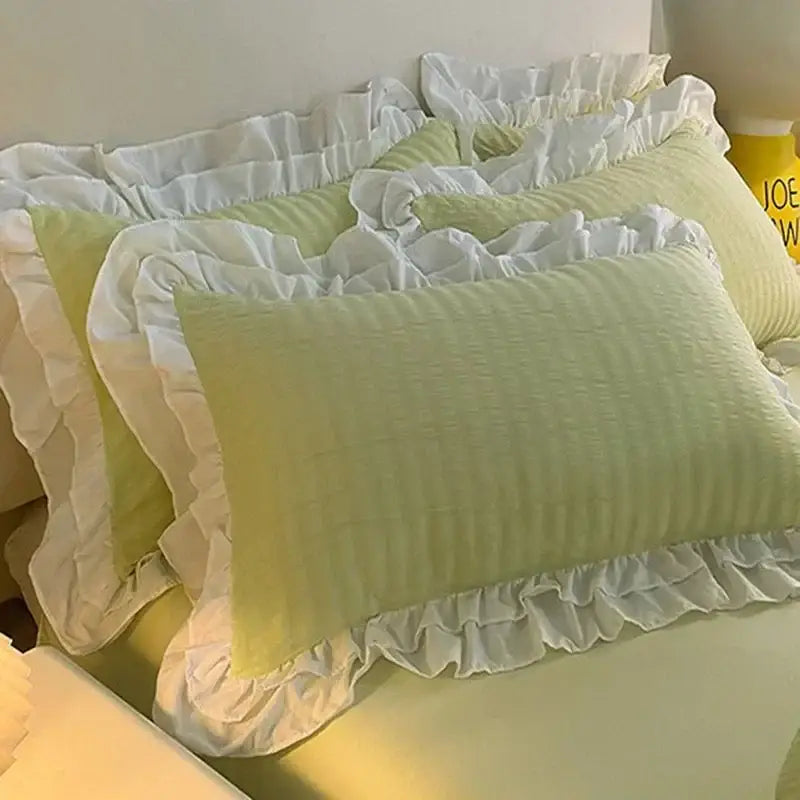 Light green pillowcases with white ruffled edges feature a subtle weave in a pastel green lace bubble cotton bedding set