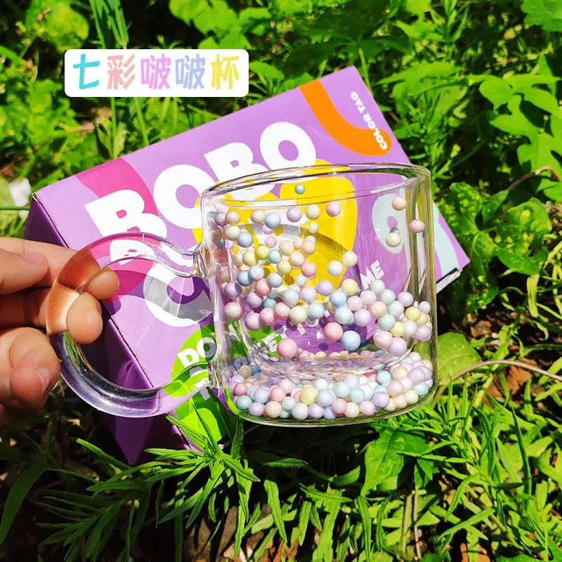 Clear glass cup with pastel heart bubble quicksand beads in a double wall design for dining room use