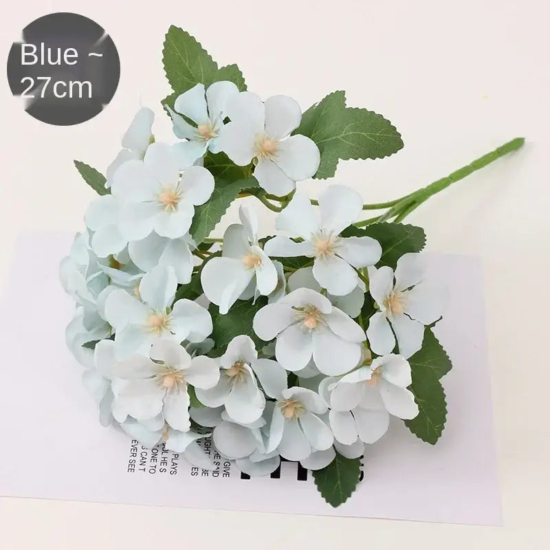 A delicate light blue begonia flower dry hydrangea bouquet with green leaves and pale yellow centers for living room decor