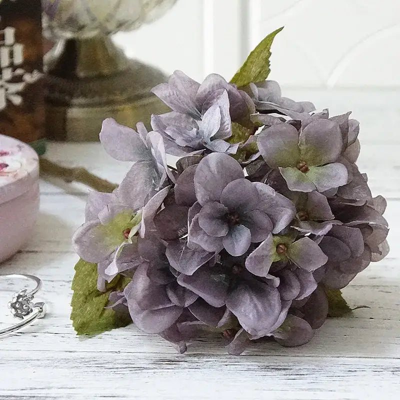 A pastel hydrangea branch silk flower bouquet in lavender and purple hues with realistic green leaves for dining room decorbites hydrangea branch decor