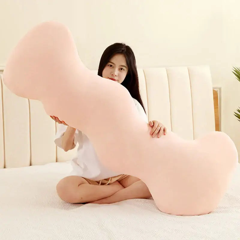 A soft blush-pink plush pillow shaped like a bone featured in decorbites ice cream wavy plush pillow bedroom decor