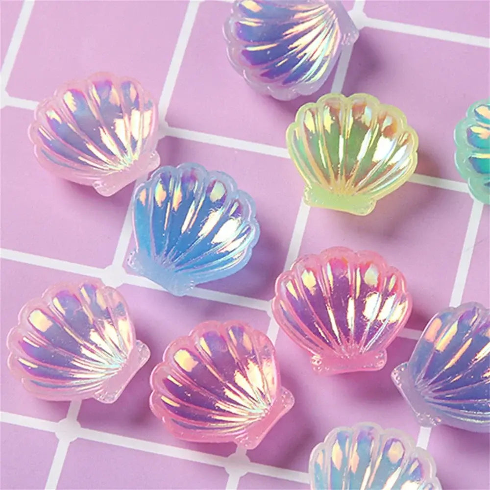 Pastel iridescent resin charms shaped like colorful pearl shells in pink blue and yellow for shells beach decor