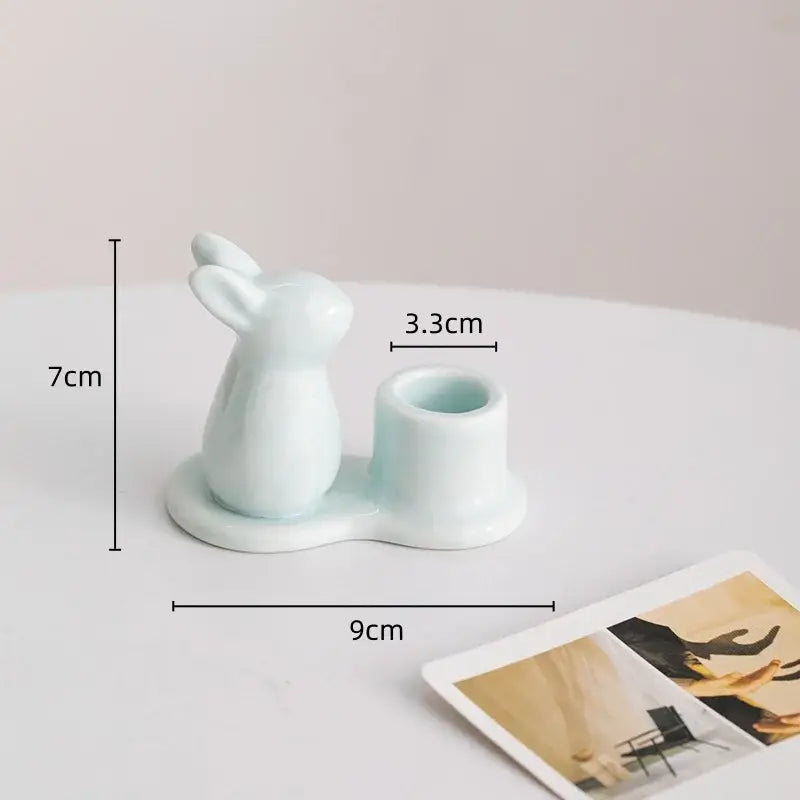 A delicate light blue bunny rabbit ceramic candle holder with an integrated cup for dining room use