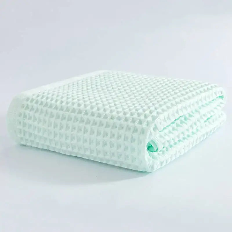 A neatly folded mint green cotton waffle bath towel from the pastel multi color decorbites cotton waffle set
