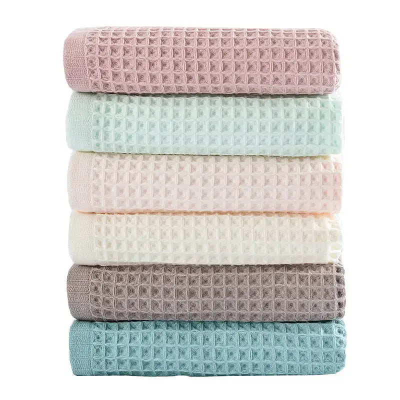 Stack of six pastel multi color decorbites cotton waffle bath towels in soft pink mint green blush peach cream white muted gray and teal blue